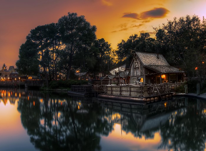Wooden house on a raft by a pond at dusk