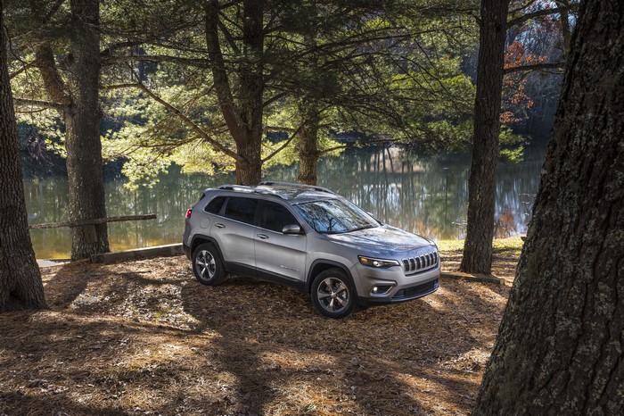 Silver Jeep Cherokee parked by a lake