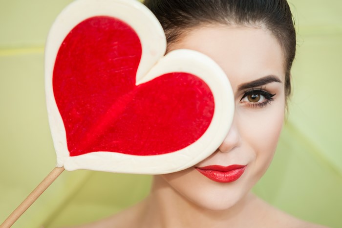 Woman holding a heart lollipop