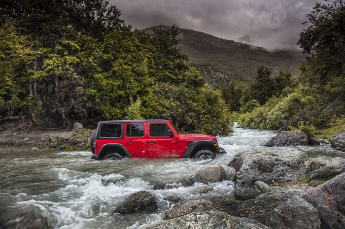 Red Jeep Wrangler Rubicon driving through a river