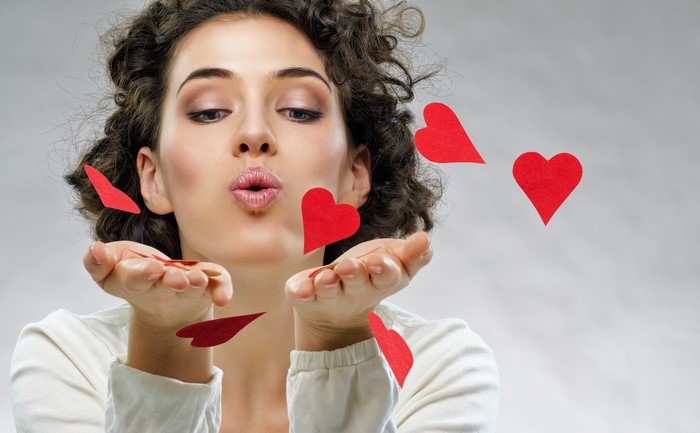 Woman blowing red hearts