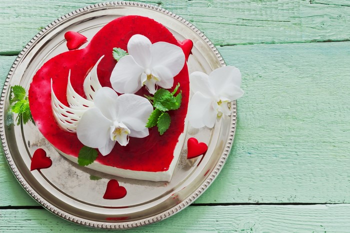 Heart-shaped cake with orchids on a silver plate