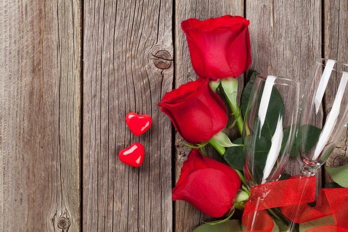Valentine's Day Red Roses and Champagne Glasses on Wood