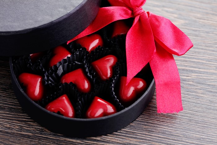 Heart-shaped chocolates in a gift box with a red bow