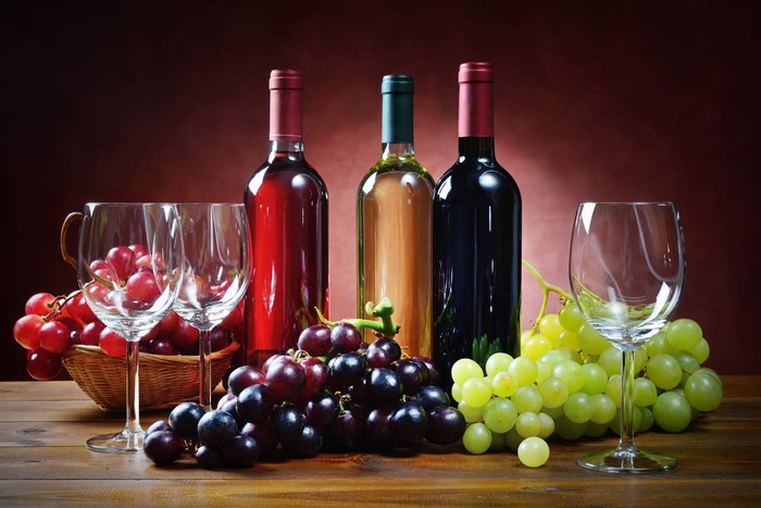 Still-life of wine bottles, grapes, and stemware