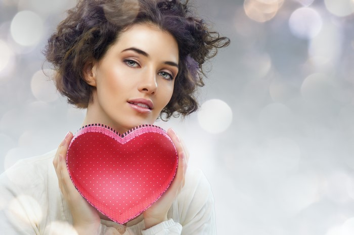 Woman holding a red heart gift box