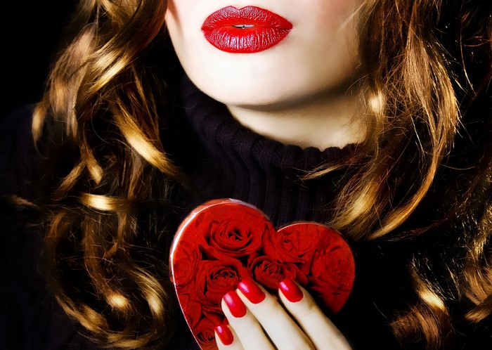 Woman with red lips holding a heart-shaped box