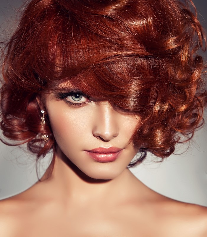 Woman with red curly hair and blue eyes