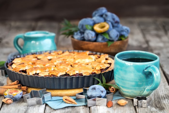 Plum pie with coffee and plums