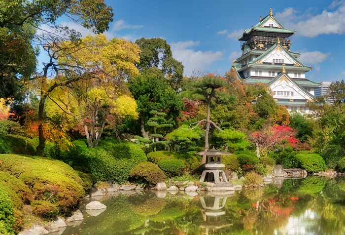 Osaka Castle park in Autumn with a pond and trees