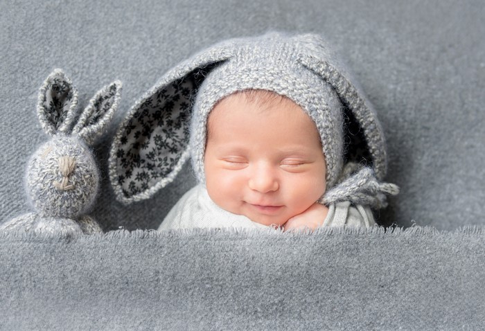 Baby in a bunny hat with a stuffed rabbit
