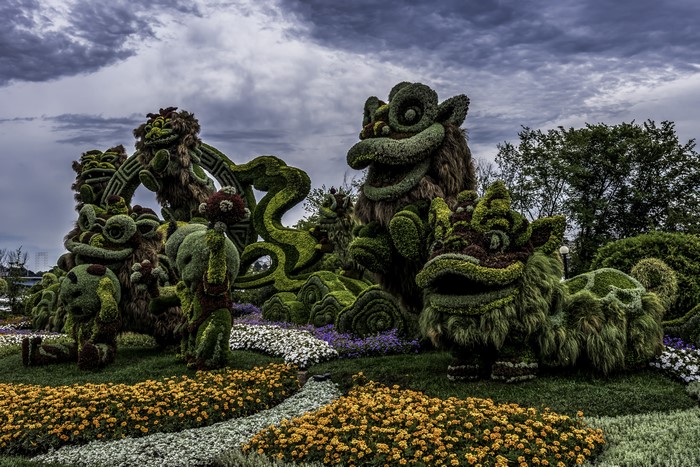 Topiary sculptures of dragons and other mythical creatures in a park