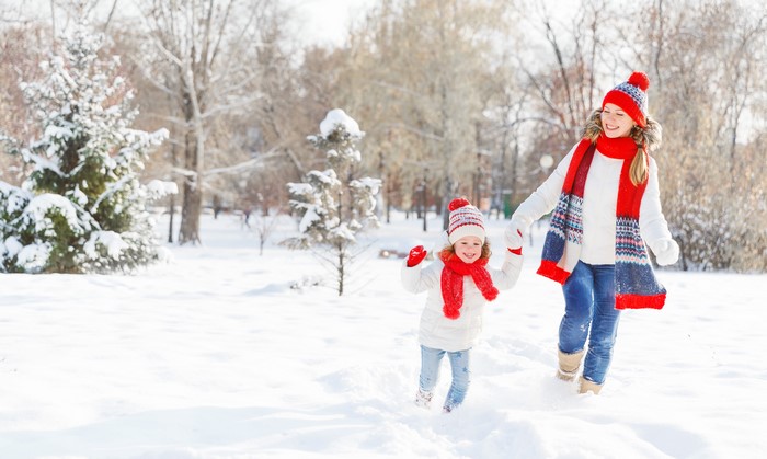 Two girls running in the snow