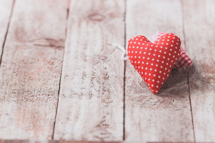 Red polka dot heart on wood planks