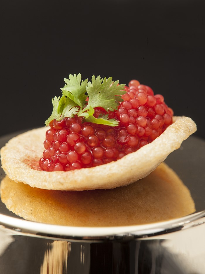 Red caviar on a chip with cilantro