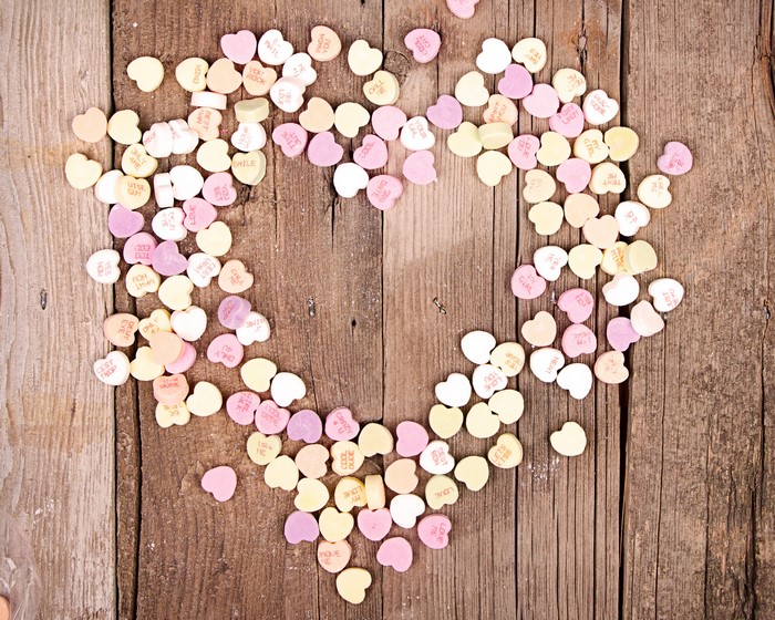 Heart shaped conversation candies on wood