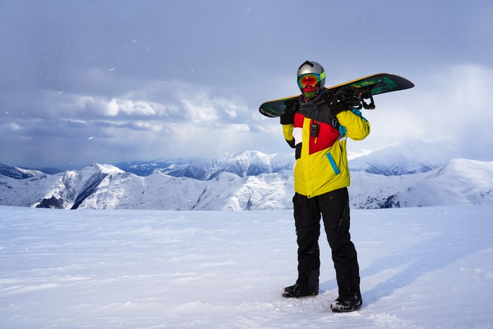 Man with snowboard in snowy mountains