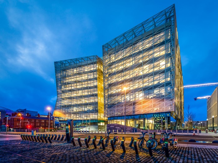 Modern glass buildings in Dublin at dusk with bicycles