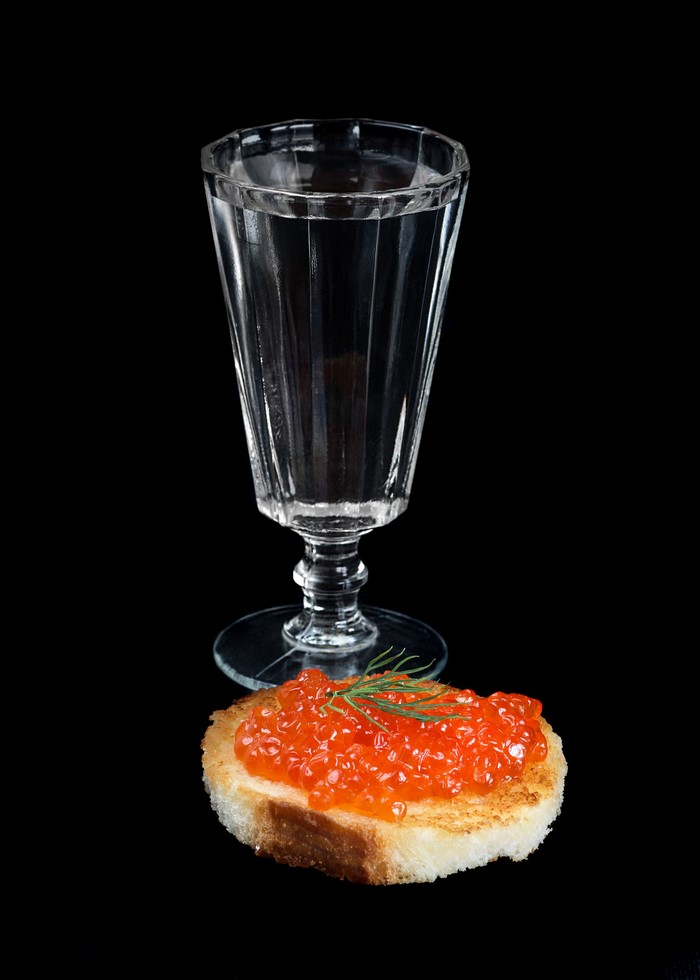 Vodka glass and caviar on toast with dill