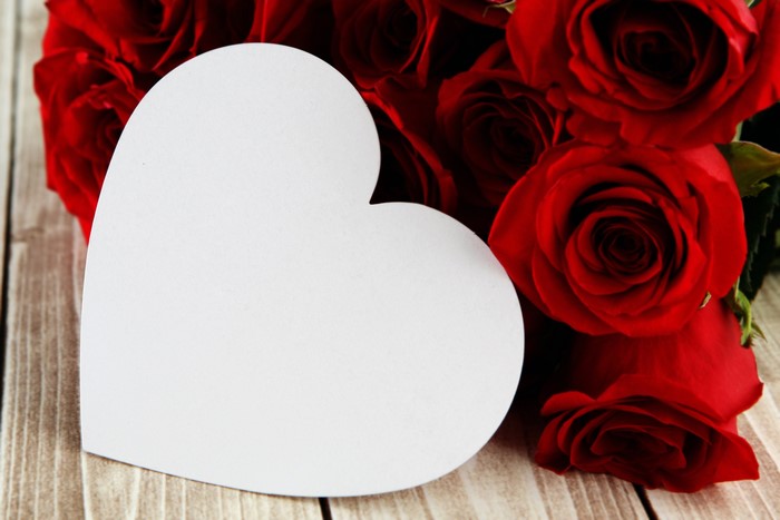 Red Roses with Heart-Shaped Card on Wooden Surface
