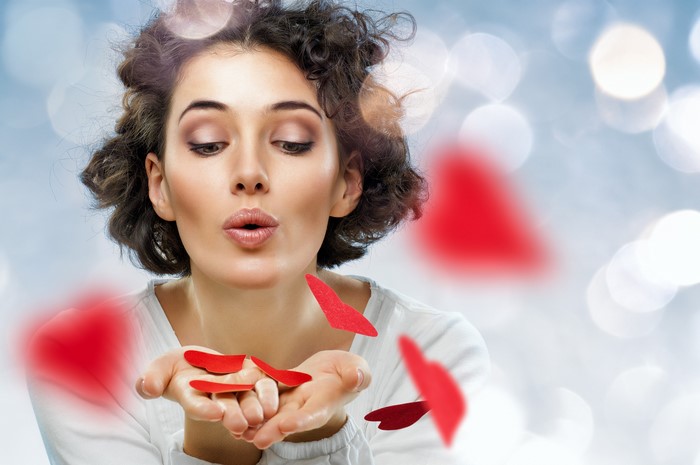 Woman blowing red hearts