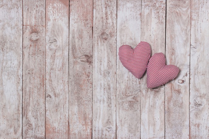 Two red and white checkered hearts on wood planks