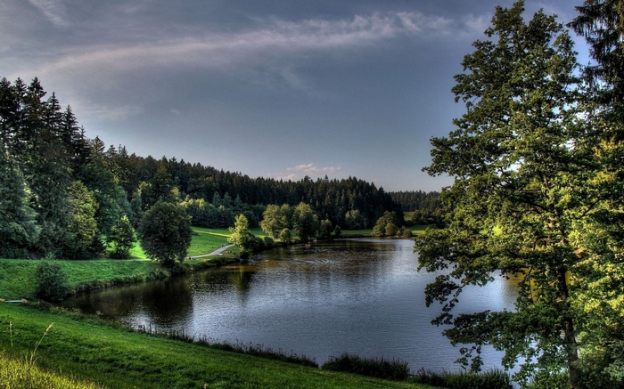 Lake surrounded by trees and green hills