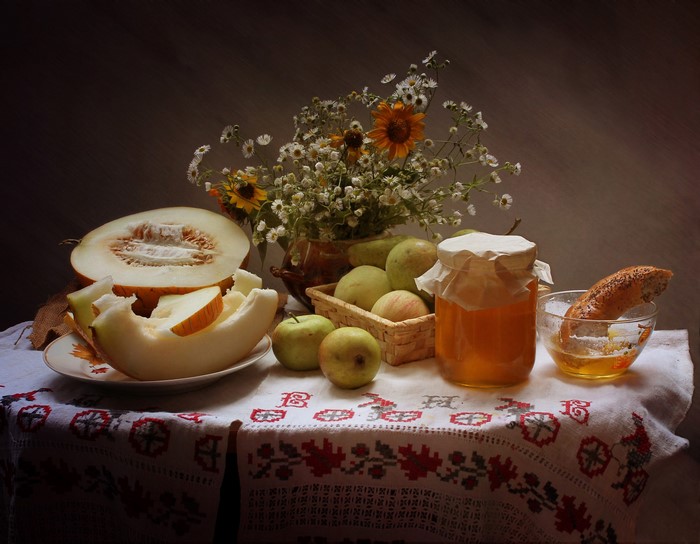 Still-life with melon, apples, honey, and flowers
