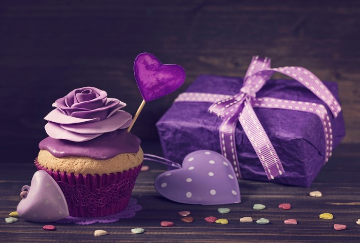 Cupcake with rose frosting and purple gift box
