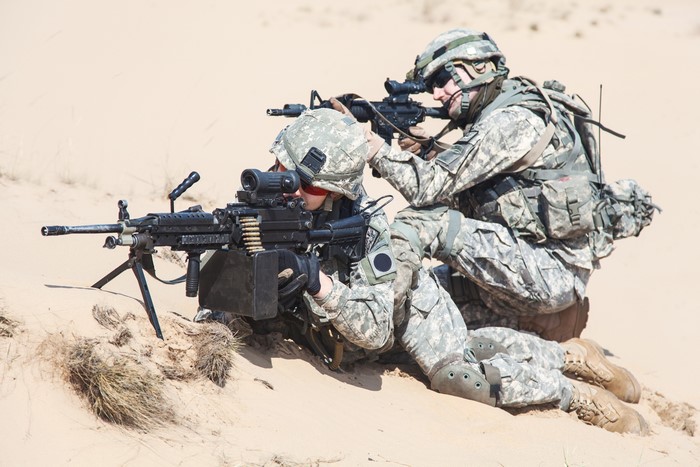Two soldiers with assault rifles in desert