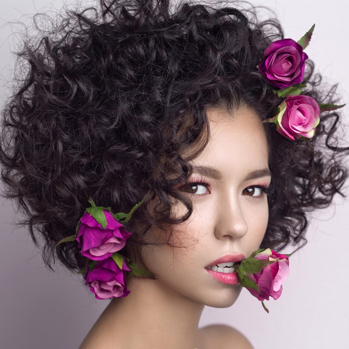 Brunette girl with curly hair and roses