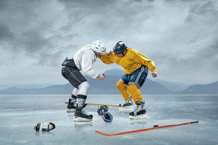 Two men fighting on ice during a hockey game