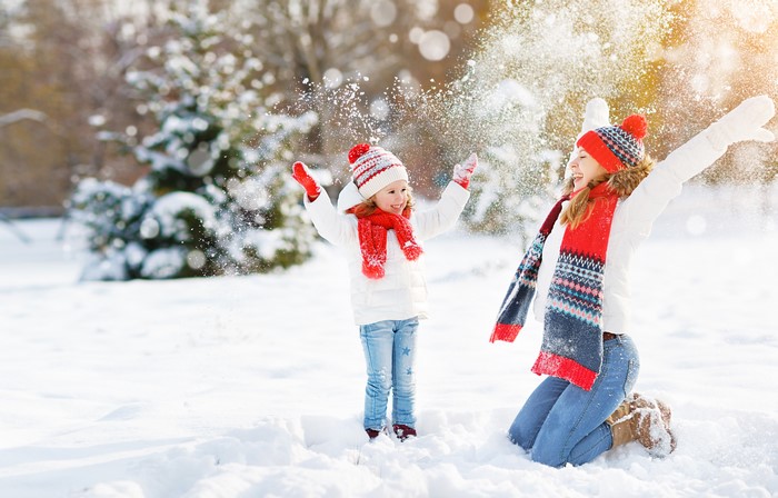 Mother and daughter playing in the snow