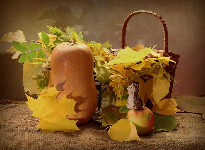 Autumn still life with pumpkin, apple, hedgehog, and basket
