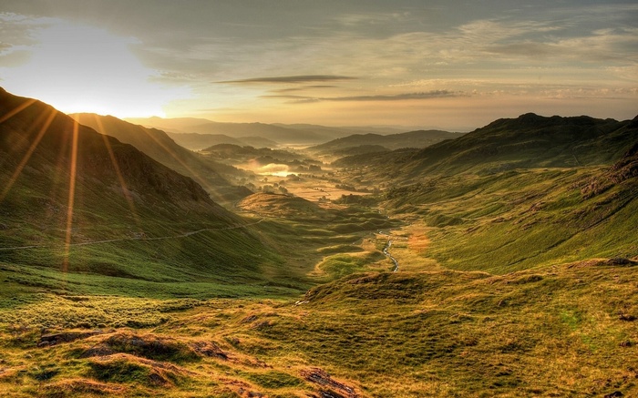 Sunlight over a misty valley and mountains