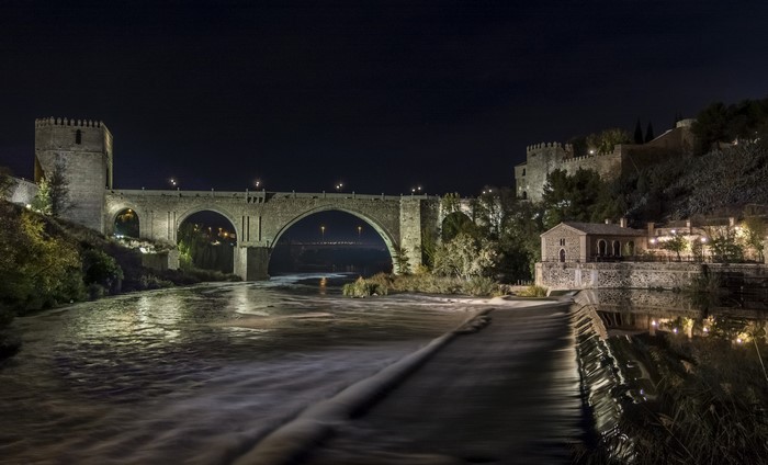 Puente de San Martín bridge over Tagus River at night in Toledo, Spain