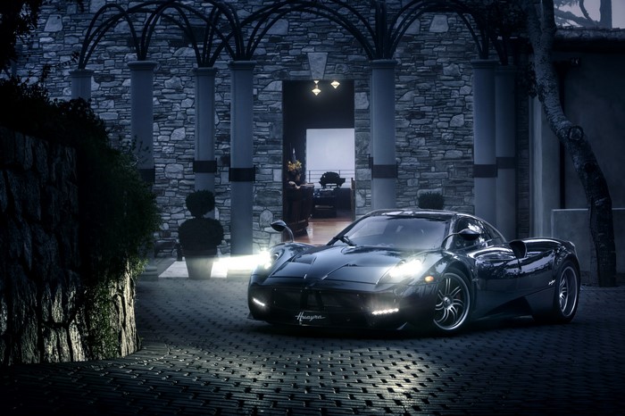 Black Pagani Huayra parked in front of a stone mansion