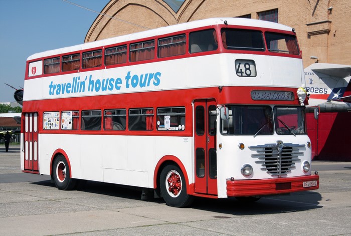 Red and white double-decker "travellin' house tours" bus