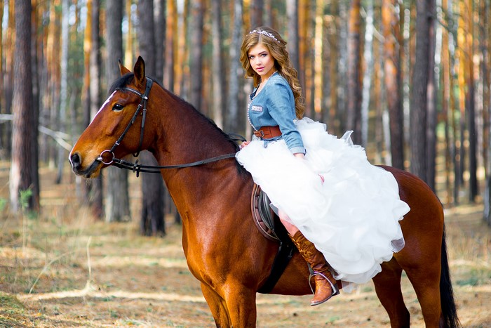 Bride on a brown horse in a forest