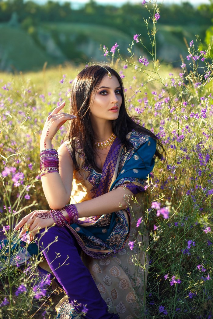 Woman in Indian attire sitting in a field