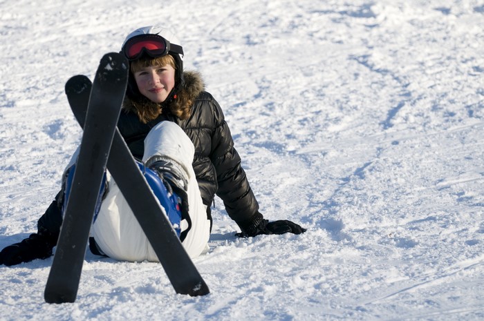 Girl in Ski Gear Sitting on Snow