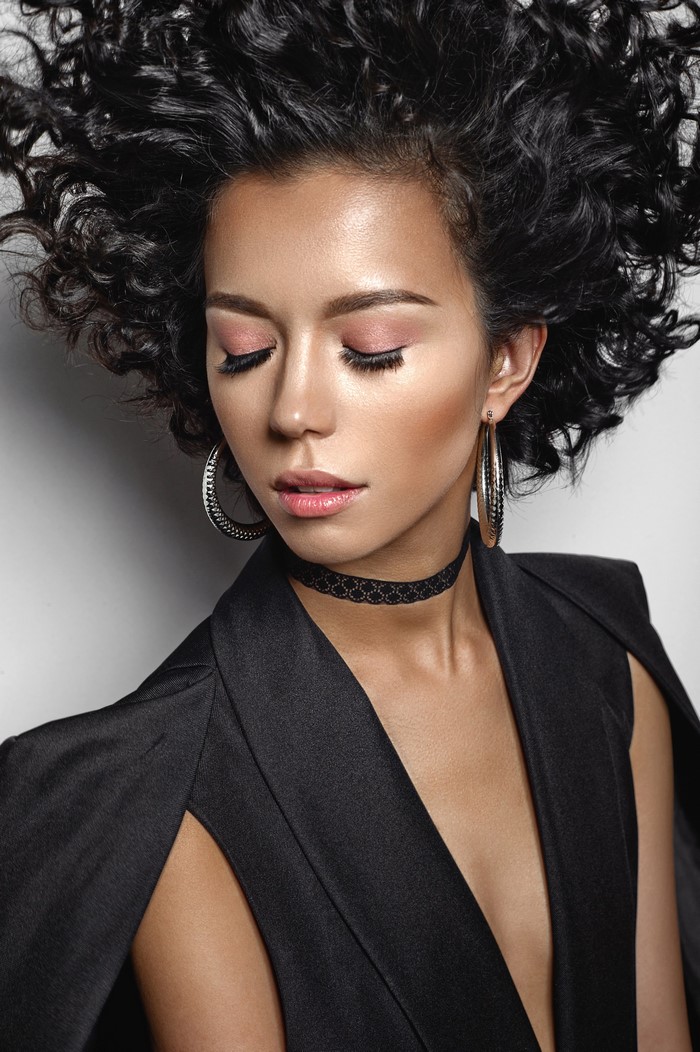 Brunette woman with curly hair and makeup
