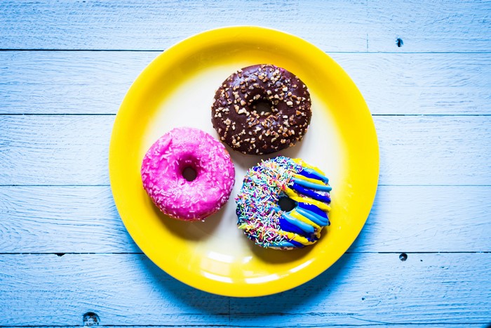 Three donuts on a yellow plate