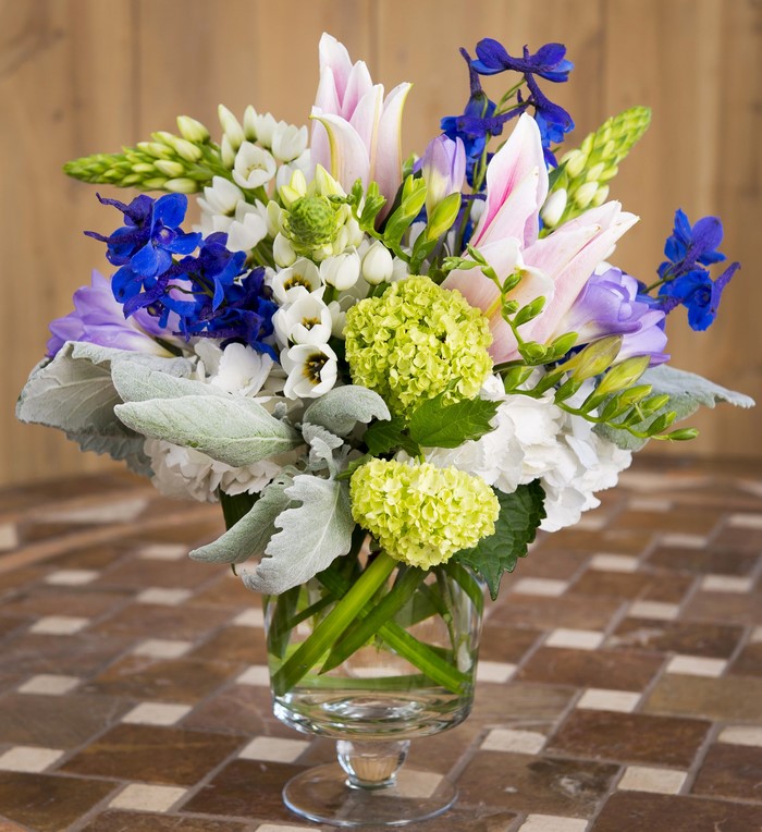 Floral arrangement with lilies, delphiniums, and hydrangeas
