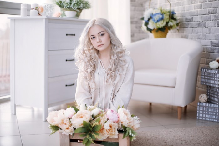 Blonde girl sitting with peonies