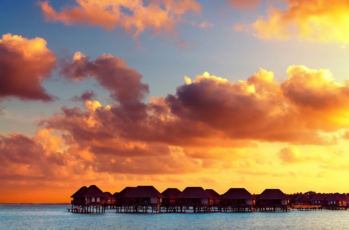 Overwater bungalows at sunset in the Maldives