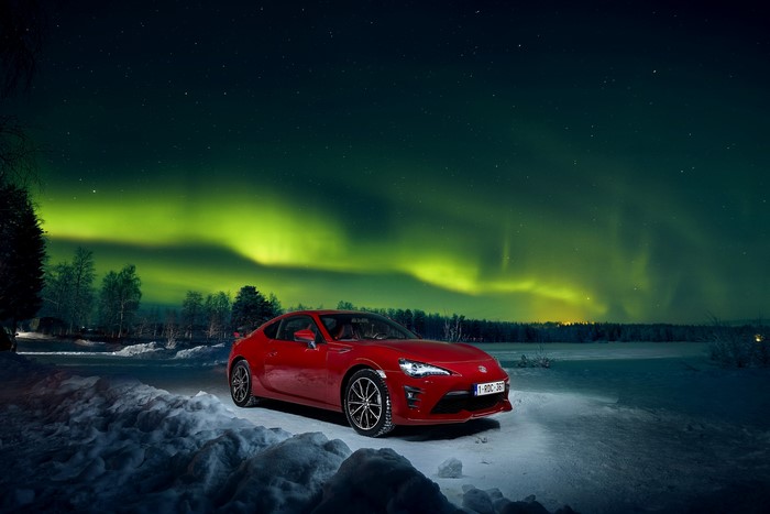 Red Toyota GT 86 under the Northern Lights