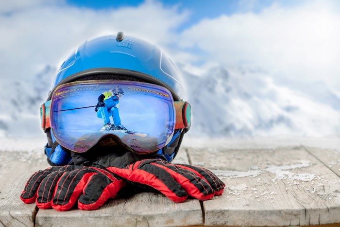 Ski helmet and gloves with skier reflection