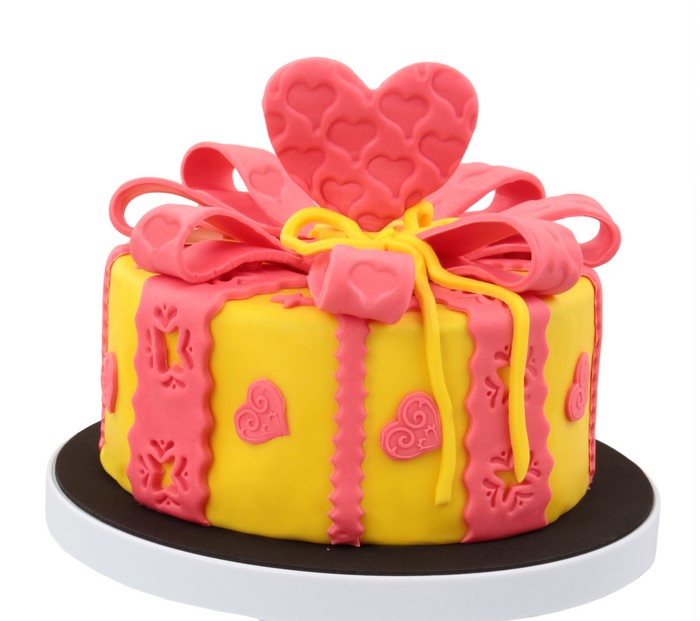 Yellow and pink gift-wrapped cake with heart decorations