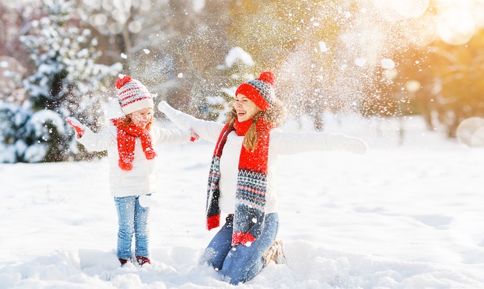 Mother and daughter playing in the snow